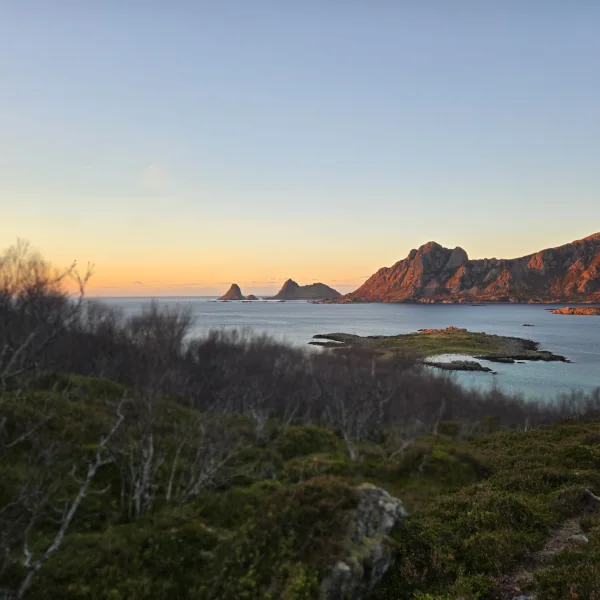 Weitblick vom Küstenpfad auf das Naturreservat Nykvåg, das offene Meer und die Bergkette