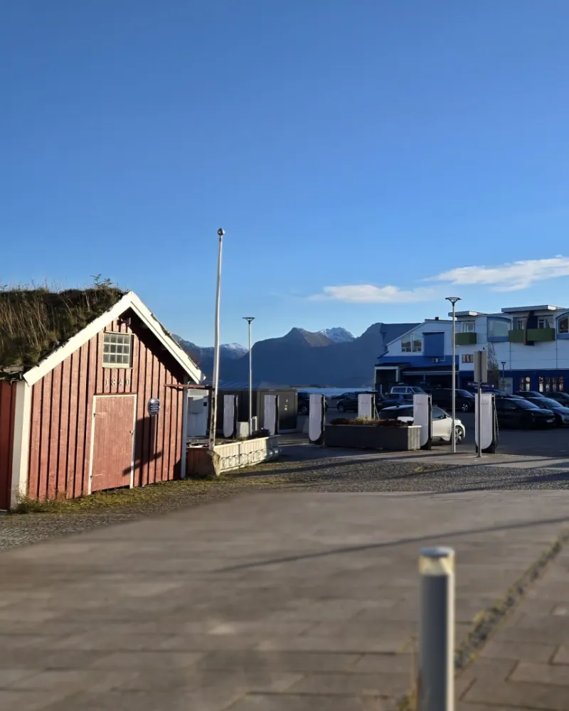 Treffpunkt an den blauen Gebäuden neben den historischen Holzhäusern aus dem 19. Jahrhundert am Hafen Sortland
