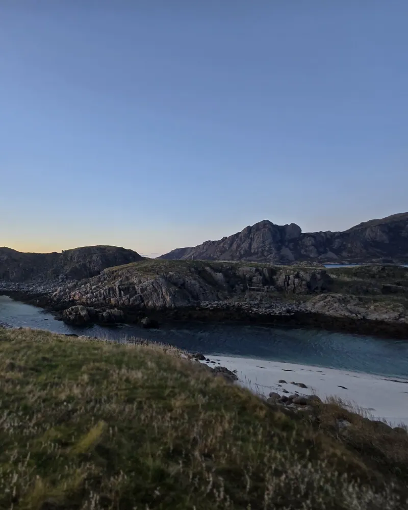 Blick vom Strand über das Wasser zu den markanten Vogelfelsen des Naturreservats Nykvåg